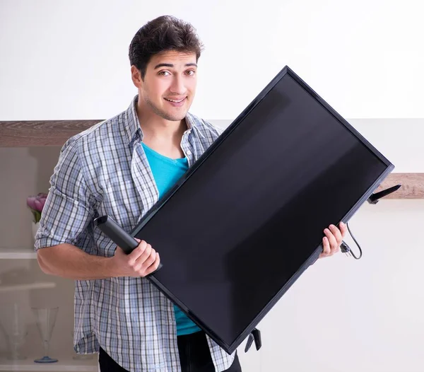 Man trying to fix broken tv — Stock Photo, Image