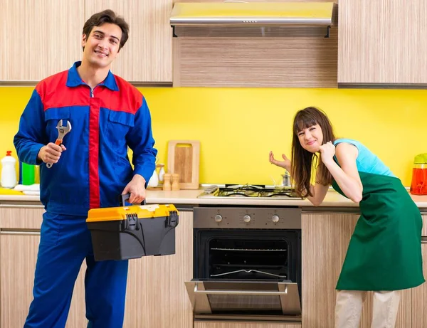 Mulher com empreiteiro na cozinha discutindo reparação — Fotografia de Stock