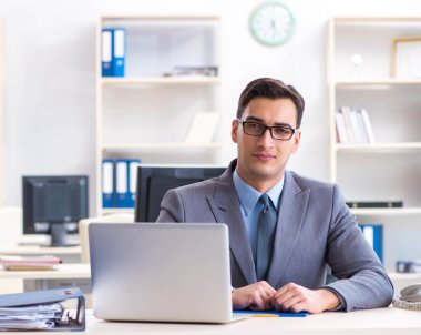 Ofisteki masasında oturan yakışıklı bir işadamı.