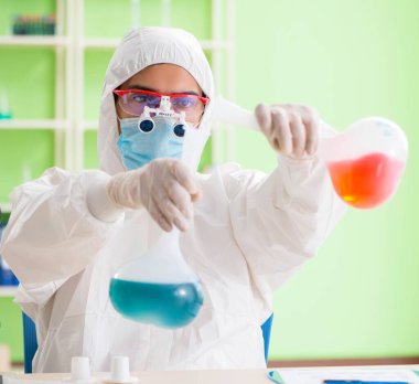 Laboratuvarda yeni bir deney üzerinde çalışan kimyager.