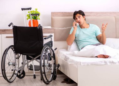 Genç yakışıklı engelli adam evde iyileşiyor.