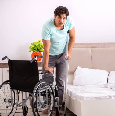 Genç yakışıklı engelli adam evde iyileşiyor.