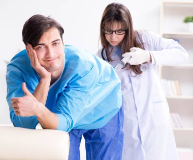 Komik adam şırınga iğnesine hazırlanıyor.