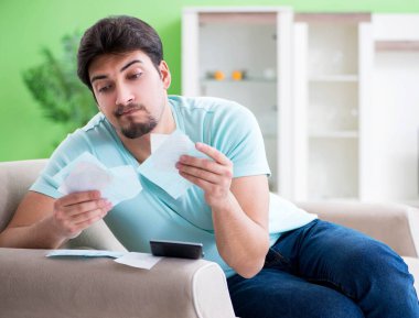 Genç adam kişisel finans ve faturalarla boğuşuyor.