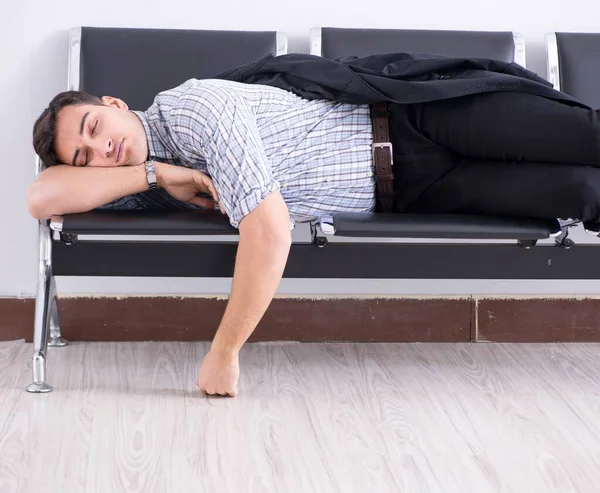 Mann schläft auf Stühlen im Flughafen — Stockfoto