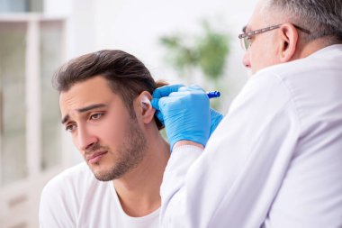 Genç adam deneyimli bir doktor olan otolargologu ziyaret ediyor.