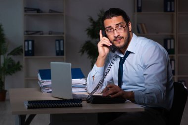 Genç işadamı ofiste geç saatlere kadar çalışıyor.