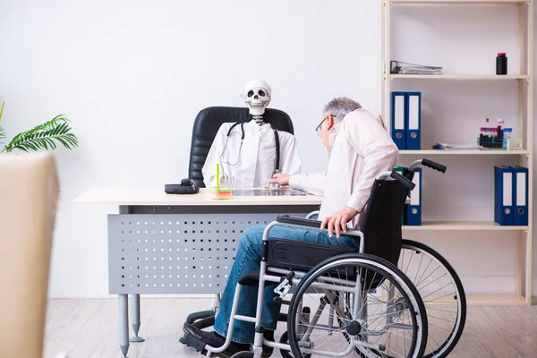 Vecchio in sedia a rotelle in visita medico morto — Foto Stock