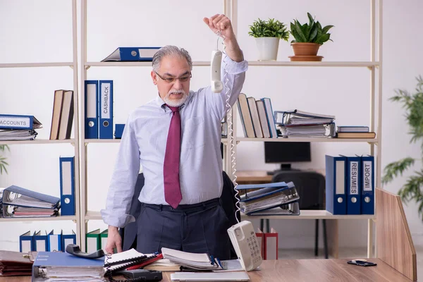 Vecchio dipendente maschio infelice con il lavoro eccessivo — Foto Stock