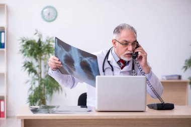 Klinikte çalışan yaşlı bir erkek radyolog.