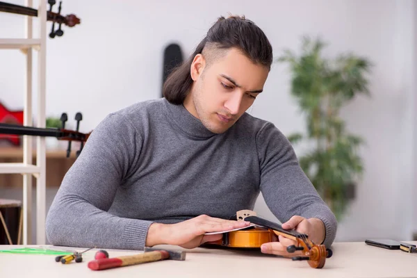 Young male repairman repairing violin — Stock Photo, Image