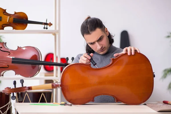 Jeune réparateur masculin réparant violoncelle — Photo
