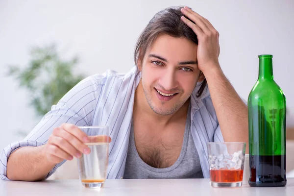 Young male alcoholic drinking whiskey at home — Stock Photo, Image