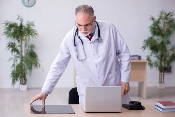 Gammal manlig röntgenläkare som arbetar på kliniken — Stockfoto