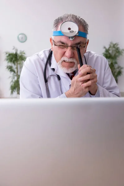 Oude mannelijke arts otoloog werkzaam in de kliniek — Stockfoto