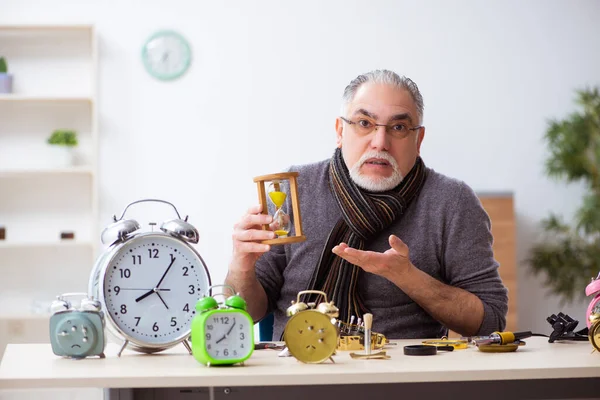 Oude mannelijke horlogemaker werkt in de werkplaats — Stockfoto