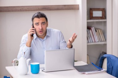 Evde çalışan genç bir erkek.