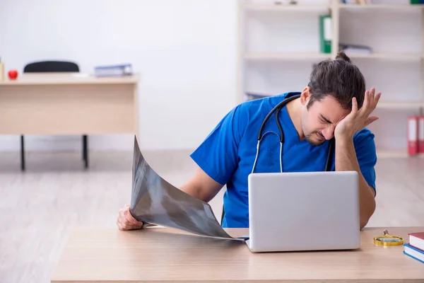 Ung manlig läkare som arbetar på kliniken — Stockfoto