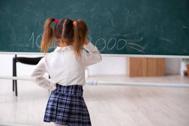 Sınıfta tahtanın önünde küçük bir kız.