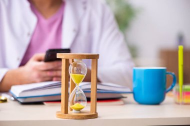 Zaman yönetimi konseptinde genç erkek fizikçi öğretmen