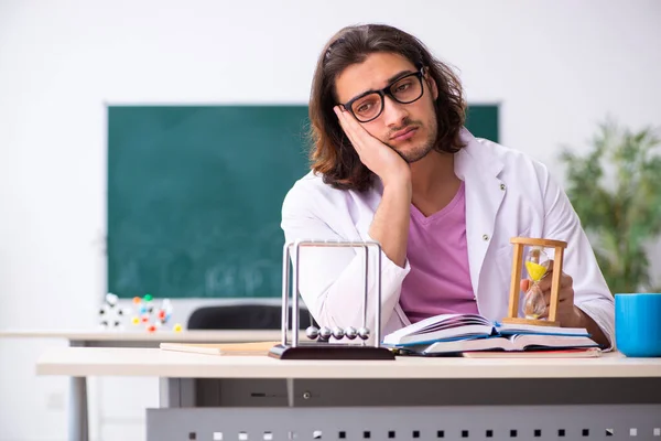 Jonge mannelijke fysicus leraar in tijdmanagement concept — Stockfoto