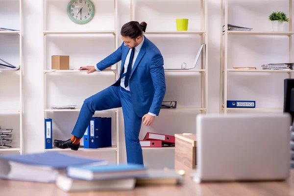 Giovane dipendente maschio infelice con il lavoro eccessivo — Foto Stock