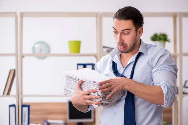 Joven empleado masculino infeliz con el trabajo excesivo — Foto de Stock