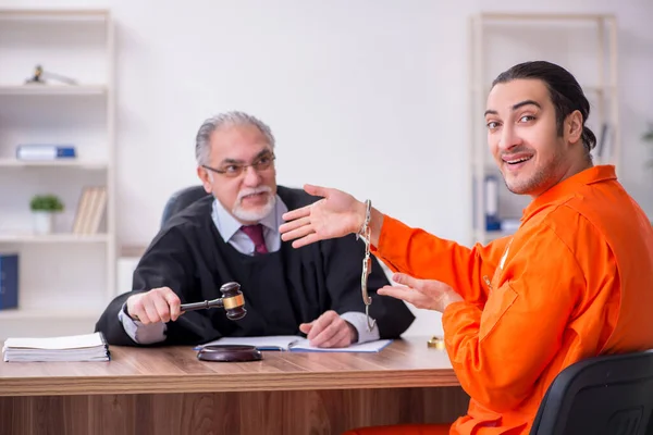 Old male judge meeting with young captive in courthouse — Stock Photo, Image