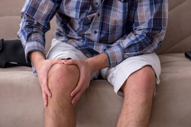 Genç bacağı yaralı adam evde acı çekiyor.