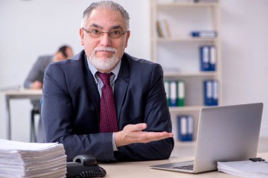 Eski patron ve genç asistanı ofiste çalışıyor.