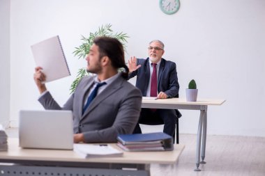 Eski patron ve genç asistanı ofiste çalışıyor.