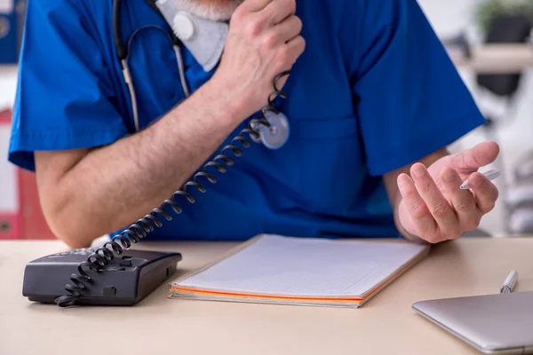 Klinikte çalışan yaşlı erkek doktor. — Stok fotoğraf