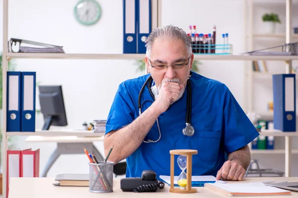 Klinikte çalışan yaşlı erkek doktor. — Stok fotoğraf