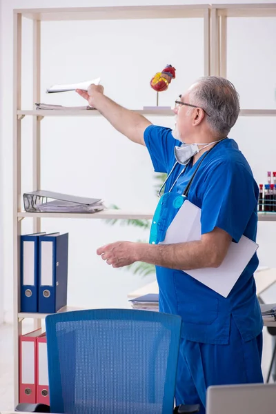 Klinikte çalışan yaşlı erkek doktor. — Stok fotoğraf