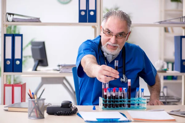 Velho médico do sexo masculino trabalhando na clínica — Fotografia de Stock