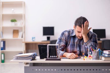 Sınıfta oturan genç erkek öğrenci.