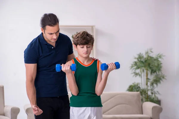 Pai e filho fazendo exercícios esportivos dentro de casa — Fotografia de Stock