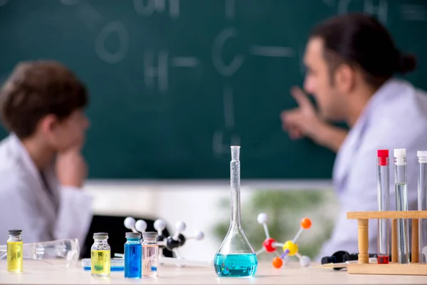 Young chemistry teacher and schoolboy in the classroom — Stock Photo, Image