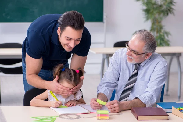 Jonge ouder, oude mannelijke leraar en klein meisje in de klas — Stockfoto