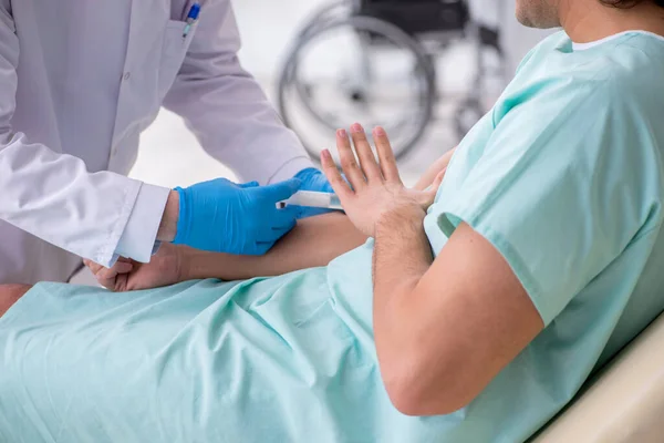 Jovem paciente do sexo masculino visitando médico experiente — Fotografia de Stock