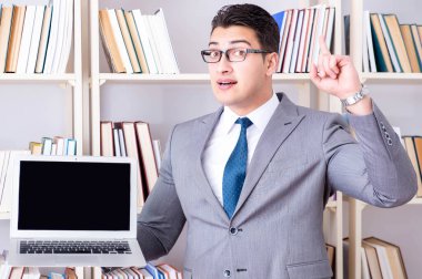 Kütüphanede çalışan boş ekran bilgisayarı olan bir iş adamı.