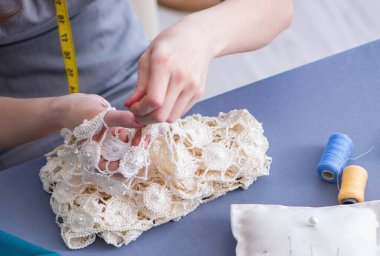 Kadın terzi dikiş dikmek için dikiş dikiyor.