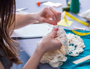 Kadın terzi dikiş dikmek için dikiş dikiyor.