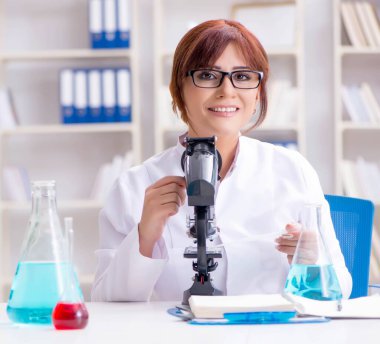 Bir laboratuarda deney yapan kadın bir bilim adamı.