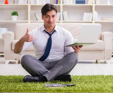 İş adamı ofiste yerde oturuyor.