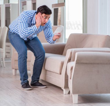 Mobilya dükkanından alışveriş yapan genç adam.