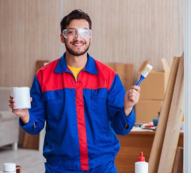 Tamirci, boyayla uğraşan marangoz.