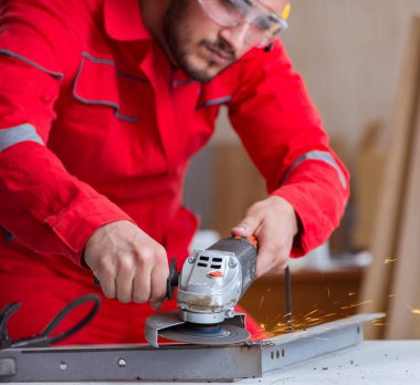 Öğütücü tekerlekle çalışan genç tamirci.