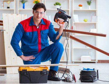 Genç marangoz tahta kalaslarla çalışıyor.