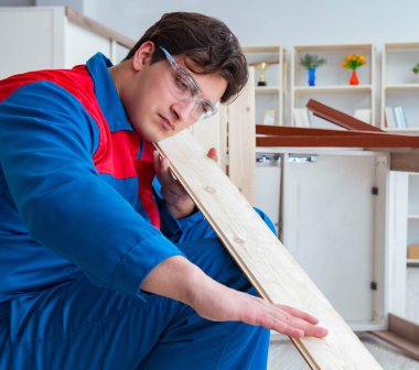 Genç marangoz tahta kalaslarla çalışıyor.